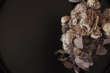 Sağ tarafta bir buket kurumuş çiçek ve siyah arka plan. Boşluğu kopyala.