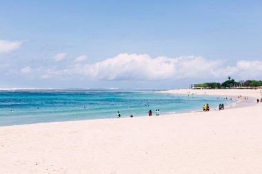 Bali, Endonezya - 2017. Güneşli bir günde yürüyen turistlerle Nusa Dua plajı.