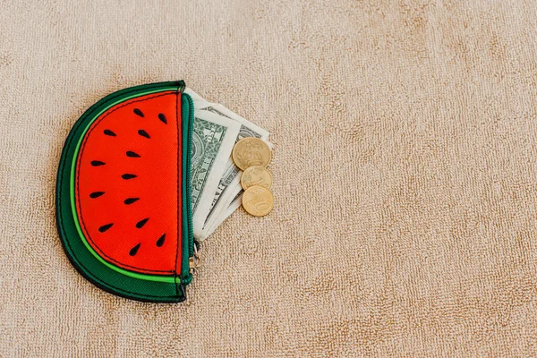 Purse with money, change and coins. Watermelon slice. Funny, bright, summer accessory. Copy space.