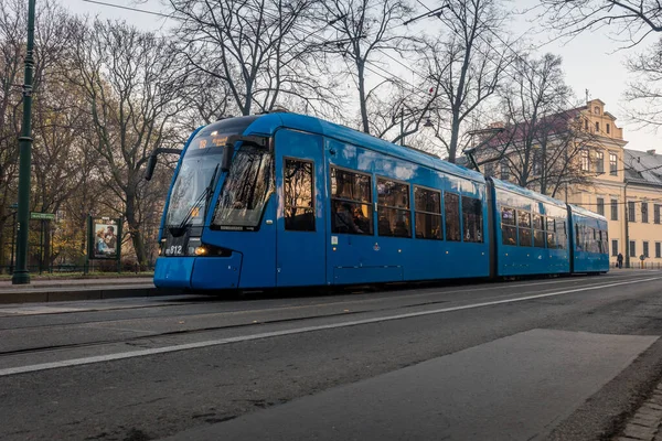 Modern bir tramvay Polonya 'nın merkezindeki bir parktan geçiyor.