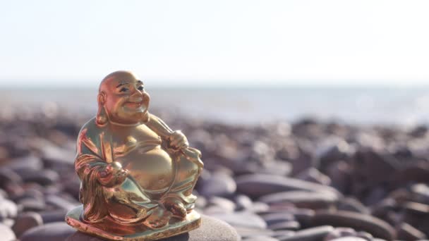 Gouden Beeldje Van Godheid Hotei Tegen Achtergrond Van Zeegolven — Stockvideo