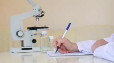 Bilim adamı laboratuarda yazıyor.