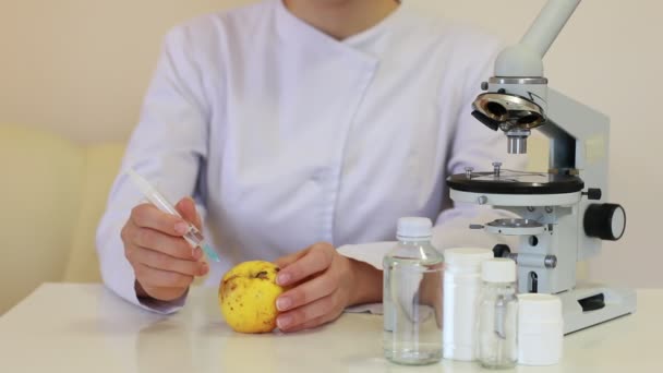 科学者は注射器でリンゴを注射する 遺伝子組み換え食品の概念 — ストック動画
