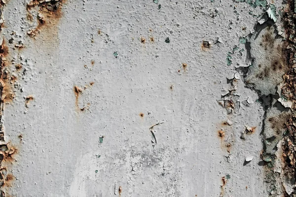 The texture of the cracked paint is a light color with traces of rust and streaks