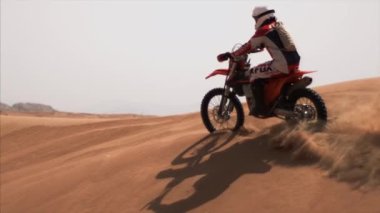 Dubai motosikletçisi çölde geziyor.
