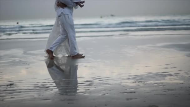 En man med en tjej går längs stranden i Dubai — Stockvideo