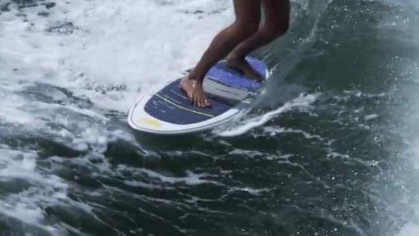 Серфер катается на доске для серфинга на волне — стоковое видео
