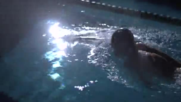 Пловец плавает в бассейне в воде — стоковое видео