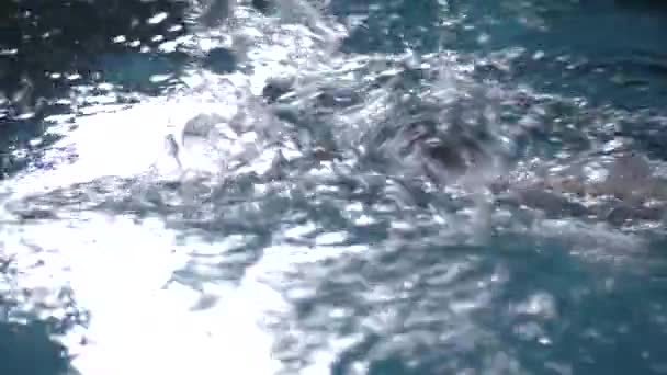 Hombre está nadando en la piscina en el agua — Vídeo de stock