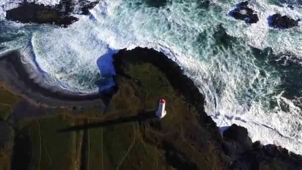 Quadro aero da Islândia, um farol que fica na costa, perto das falésias e montanhas — Vídeo de Stock