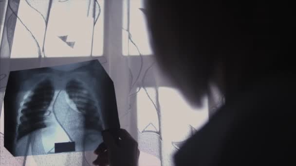 Medico in ospedale, viene alla finestra con una radiografia — Video Stock