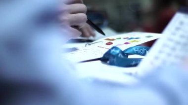 İş konferansındaki bir adam kağıda ve diyagrama kalemle yazar.