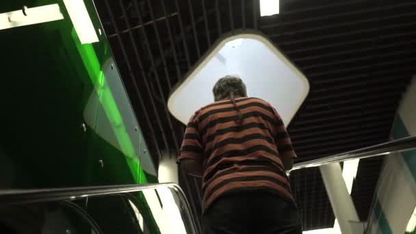 Seorang pria berdiri di eskalator dan naik ke atas untuk konferensi bisnis — Stok Video