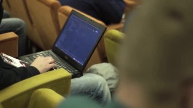 Programcı bir konferansta bilgisayara kod yazar