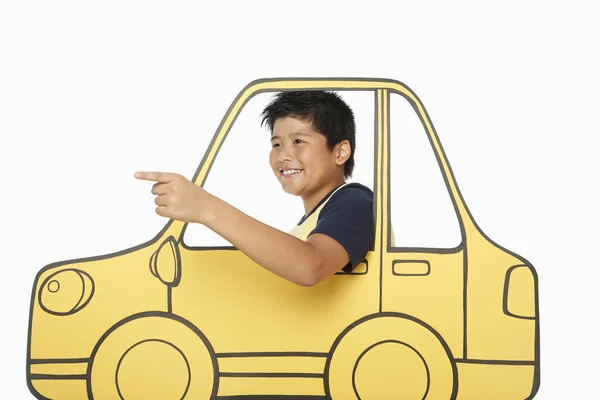 Junge Blickt Aus Einem Autofenster Aus Pappe Und Zeigt Nach — Stockfoto