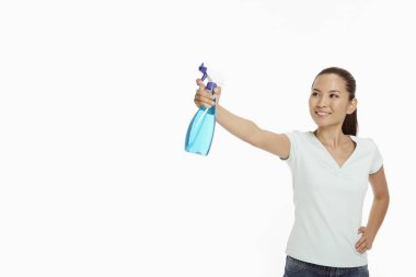 Elinde sprey şişesi tutan kadın.