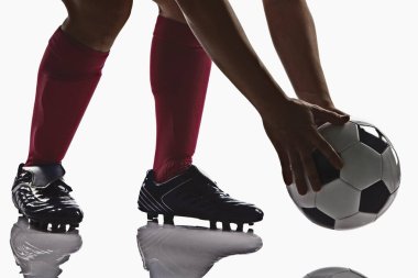 Futbol topu tutan bir futbolcu.