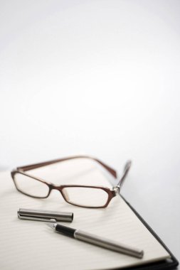 Not defterinde gözlük ve kalem var.