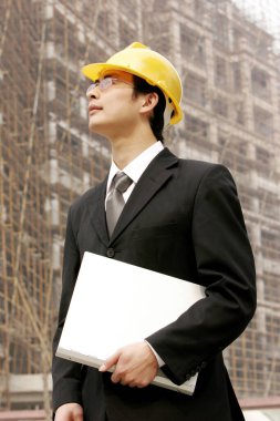 İnşaat alanında kasklı bir adam.