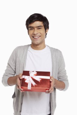 Kırmızı bir hediye kutusu tutan adam.