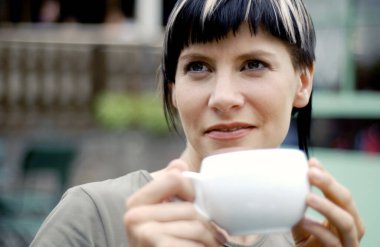 Bir kadın bir fincan kahve içiyor.