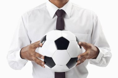 Futbol menajeri elinde top tutuyor.