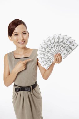 İş kadını bir yığın parayı işaret ediyor