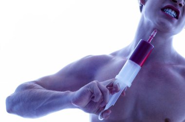 Gömleksiz bir adam boynuna şırınga enjekte ediyor.