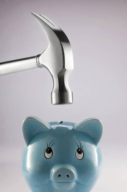 Domuz kumbarasının tepesinde çekiç