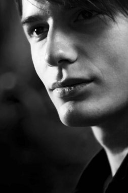 Bir adamın siyah beyaz yakın plan fotoğrafı.