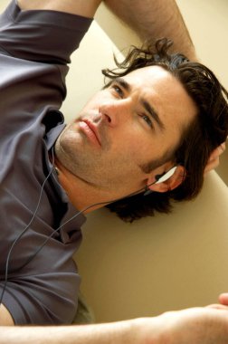 A man with hands free lying on the couch