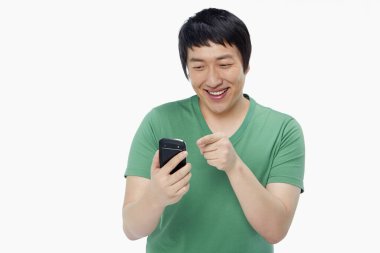 Neşeli adam cep telefonuyla mesaj atıyor.