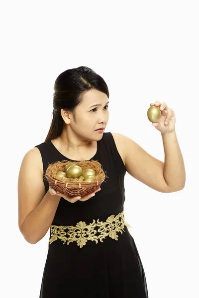 Mujer Mirando Huevo Dorado Con Curiosidad — Foto de Stock