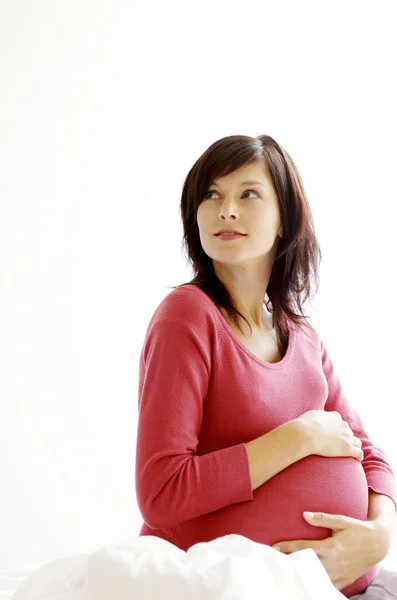 Eine Schwangere Frau Sitzt Auf Dem Bett Und Berührt Ihren — Stockfoto