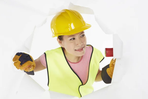 Construction worker looking through a hole on the wall