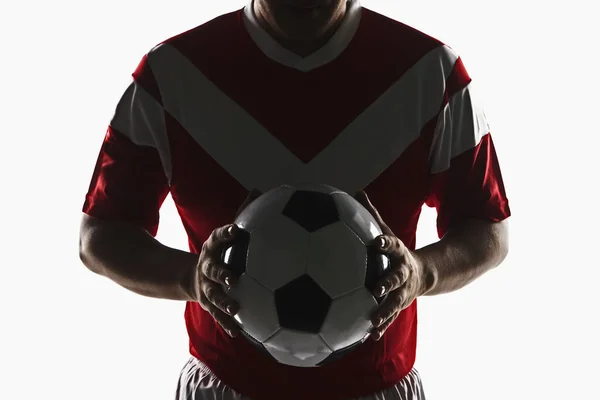 A soccer player holding a soccer ball