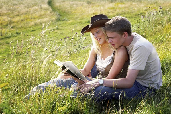 Couple Sitting Grass Reading Book — Stockfoto