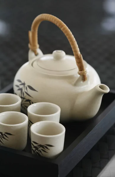 四个茶杯和茶壶放在盘子里 图库图片