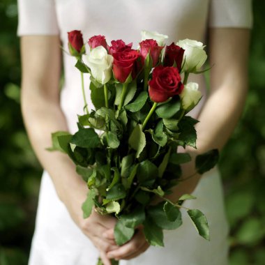 Bir buket çiçek tutan bir kadın.