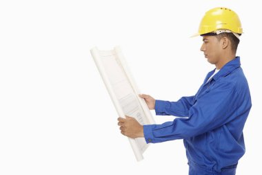 İnşaat işçisi bir plan üzerinde çalışıyor.