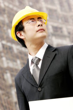 İnşaat alanında kasklı bir adam.