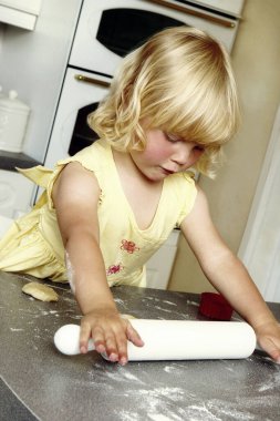 Tahta bir oklavayla oynayan kız.