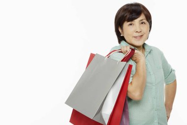 Gülümseyen ve alışveriş torbaları taşıyan bir kadın