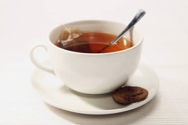 Yanında bisküvi olan bir fincan çay.