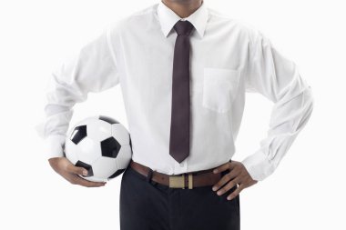 Futbol menajeri elinde top tutuyor.