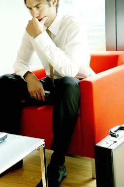 Kanepede oturup düşünen bir iş adamı