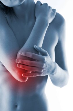 Ağrıyan dirseğine dokunan bir kadın