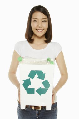 Woman holding up a recycling bin filled with plastic bottles clipart