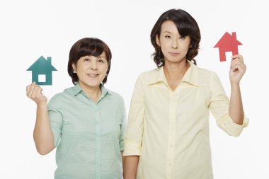 Farklı yüz ifadeleri olan kadınlar bir evi soyuyor.