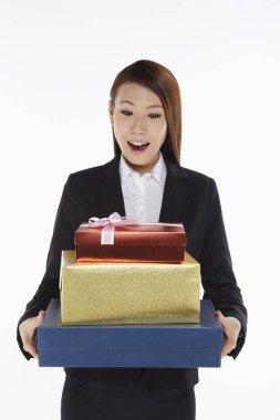 İş kadını bir yığın hediye kutusu taşıyor.